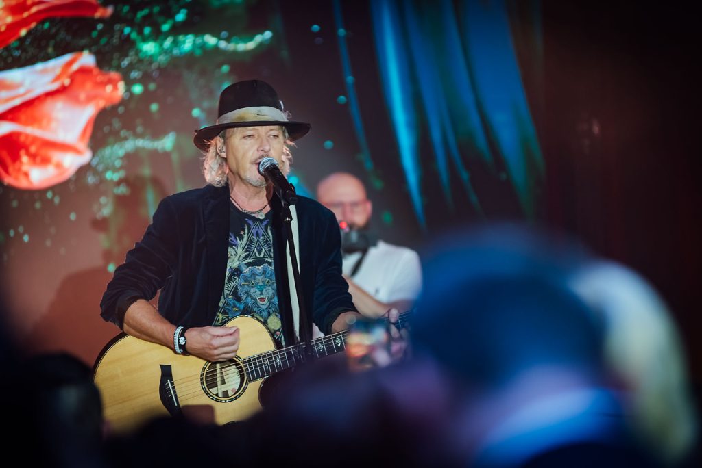 Spevák v klobúku s akustickou gitarou počas vystúpenia Peter Nagy a Indigo