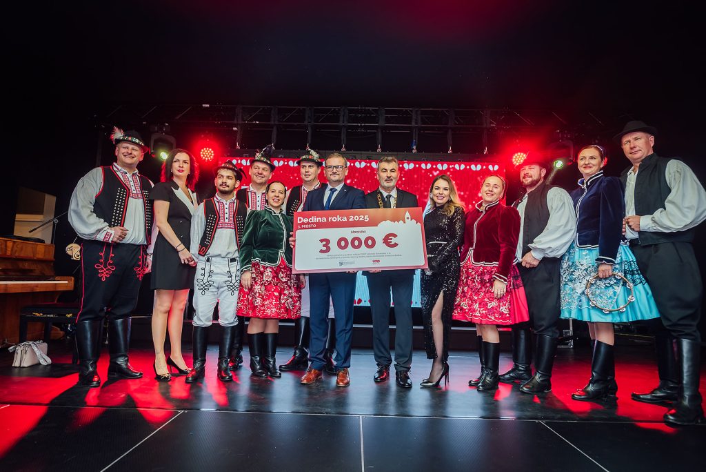 Folklórne skupiny v krojoch na pódiu so symbolickým šekom na 3 000 €