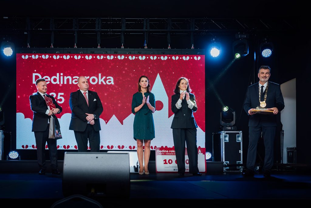 Predstavitelia obcí a organizátori na pódiu s ocenením pred obrazovkou Dedina roka 2025